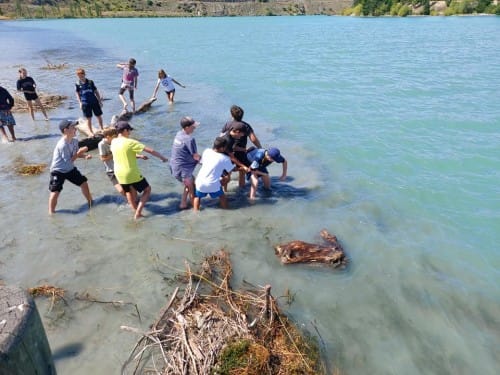 Working bee: Young Cromwell residents have a go at clearing the debris of the ever-growing beaches of silt in the Kawarau Arm of Lake Dunstan.